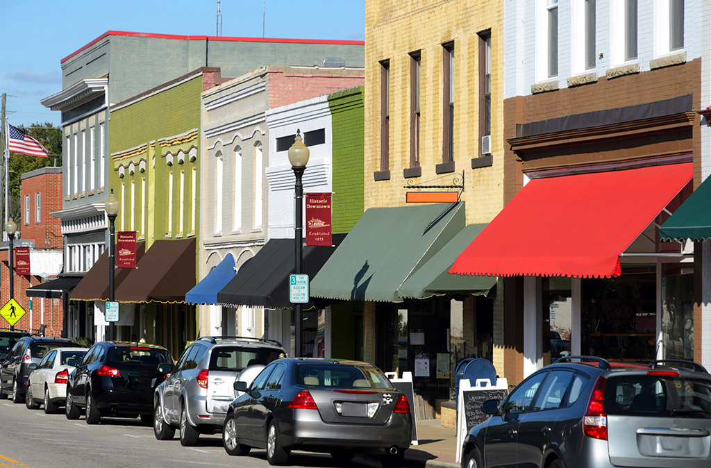 Cars parked on the street with businesses with business insurance Insurance in Walton